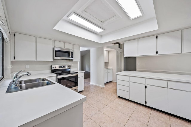 kitchen featuring white cabinets, light tile patterned flooring, appliances with stainless steel finishes, and sink