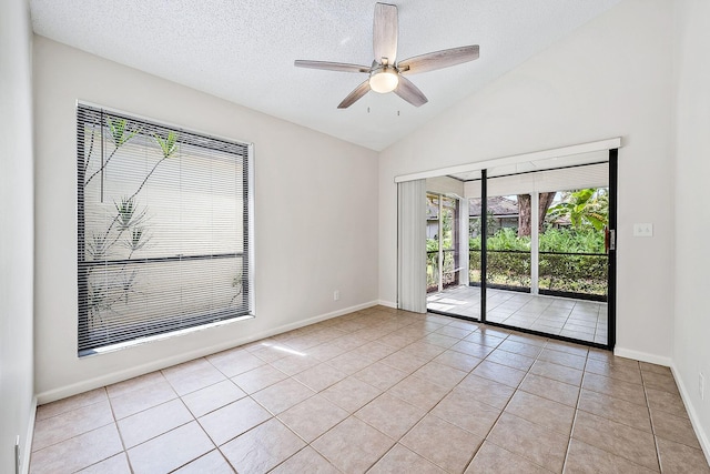 tiled spare room featuring ceiling fan, a textured ceiling, and vaulted ceiling