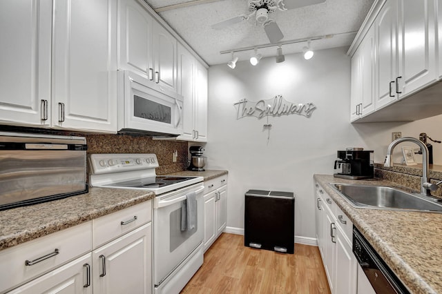 kitchen with light hardwood / wood-style floors, sink, white cabinetry, white appliances, and ceiling fan