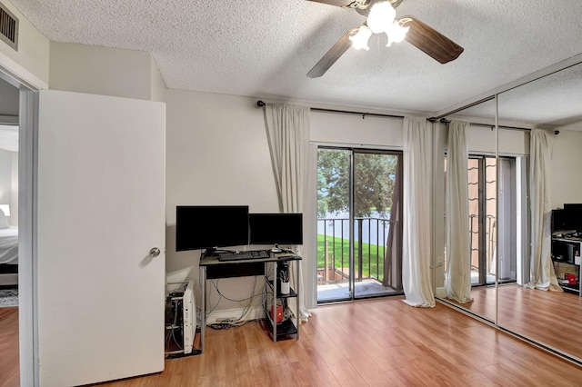 office area featuring wood-type flooring, ceiling fan, and a textured ceiling