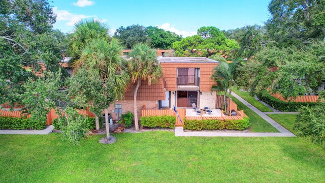 view of front of home with a wooden deck and a front yard