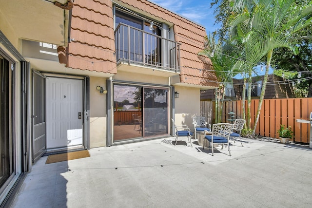 back of property featuring a balcony and a patio