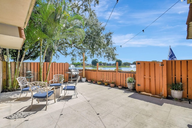 view of patio / terrace featuring grilling area and a water view