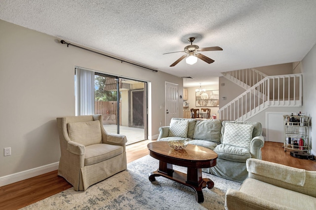 living room with a textured ceiling, ceiling fan, and hardwood / wood-style flooring