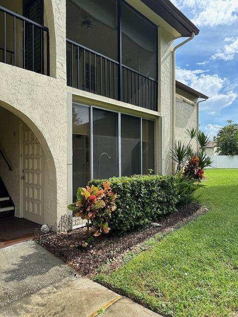 3625 La Aires Ct Unit B-1, Greenacres, FL 33463 - exterior space with stucco siding and a lawn