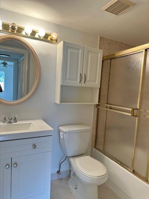 full bathroom with enclosed tub / shower combo, vanity, toilet, and tile patterned floors