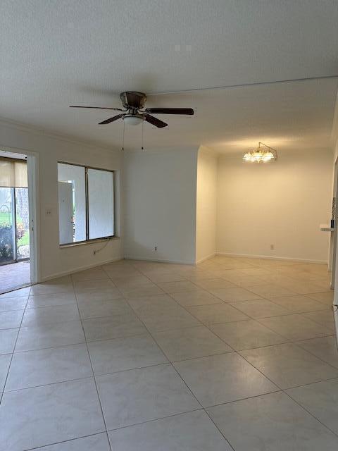 spare room featuring ceiling fan, a textured ceiling, and light tile patterned floors