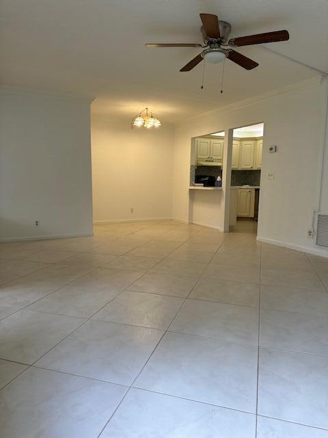 3625 La Aires Ct Unit B-1, Greenacres, FL 33463 - empty room featuring ceiling fan with notable chandelier, light tile patterned floors, baseboards, and visible vents