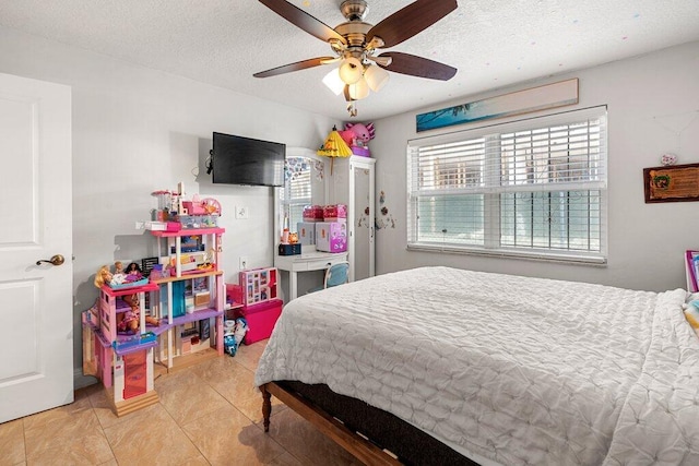 bedroom with ceiling fan, light tile patterned flooring, and a textured ceiling