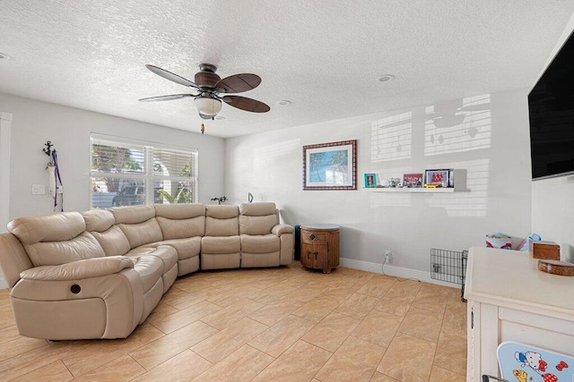 living room with ceiling fan and a textured ceiling