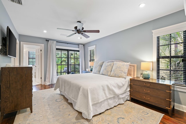 bedroom with ceiling fan, wood-type flooring, and multiple windows