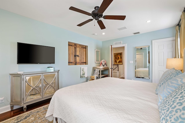 bedroom with ceiling fan, connected bathroom, and wood-type flooring