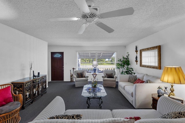 living room with a textured ceiling, dark colored carpet, and ceiling fan