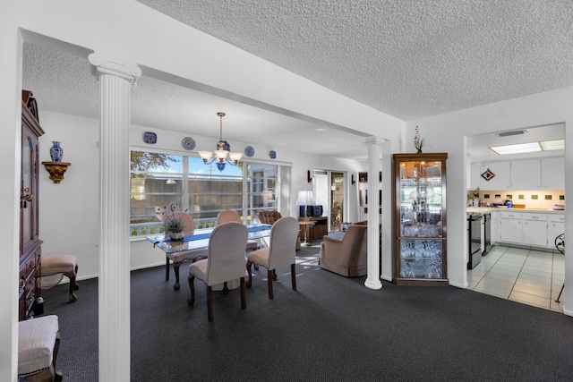 dining area with a textured ceiling, decorative columns, an inviting chandelier, and light tile patterned floors