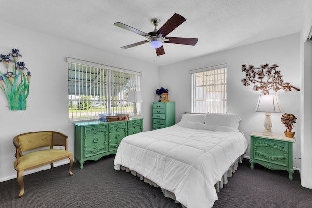 bedroom with ceiling fan, a textured ceiling, and dark carpet