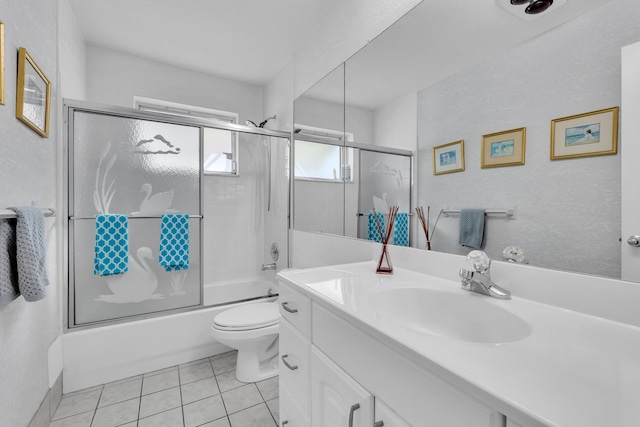 full bathroom featuring shower / bath combination with glass door, tile patterned flooring, vanity, and toilet