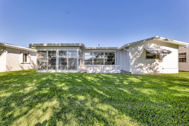 back of property with a yard and a sunroom