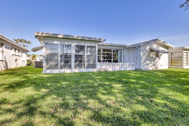 rear view of property with a lawn and central AC