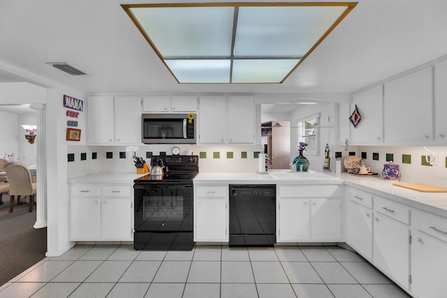 kitchen featuring black appliances, light tile patterned floors, and white cabinets