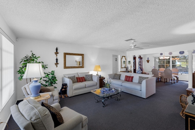 carpeted living room with ceiling fan and a textured ceiling