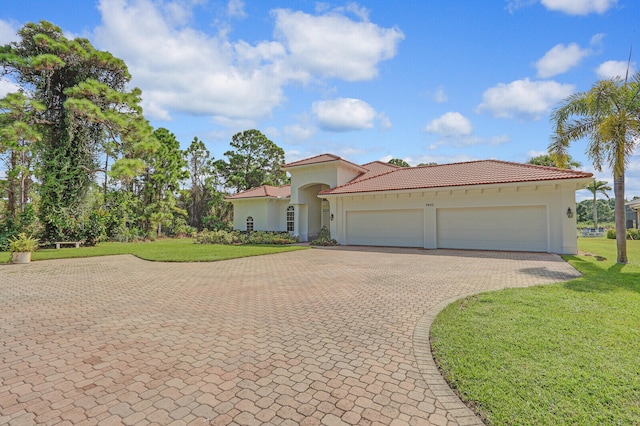 mediterranean / spanish home with a front yard and a garage