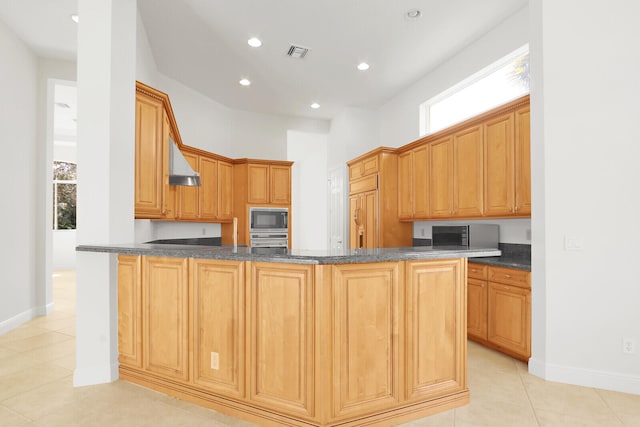 kitchen featuring kitchen peninsula, plenty of natural light, built in appliances, and extractor fan