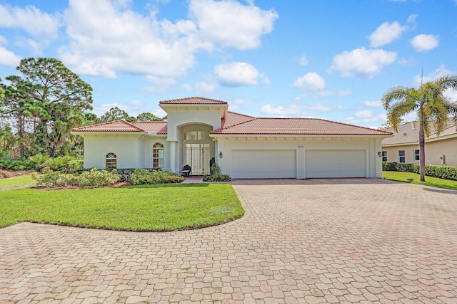 mediterranean / spanish-style house with a garage and a front yard