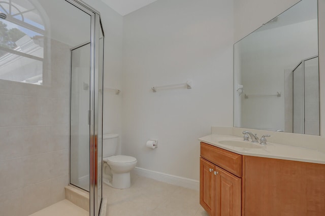 bathroom with vanity, toilet, tile patterned floors, and a shower with door