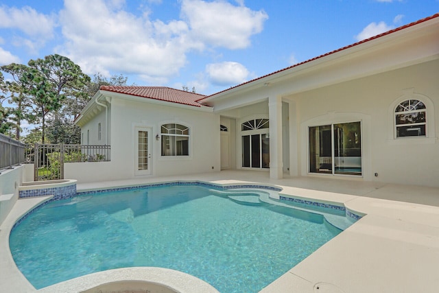 view of swimming pool featuring a patio and a hot tub