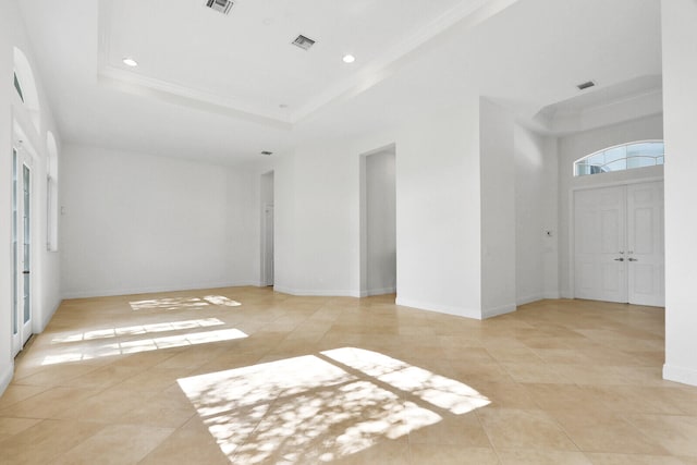 tiled spare room featuring a raised ceiling