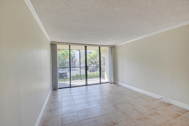 tiled spare room featuring a textured ceiling, a wall of windows, and ornamental molding