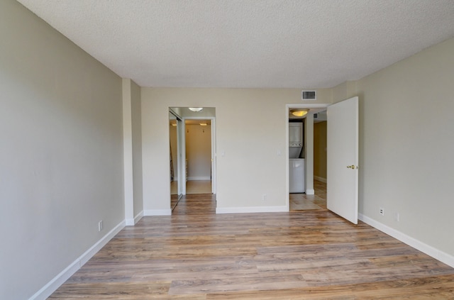 spare room with a textured ceiling and light wood-type flooring