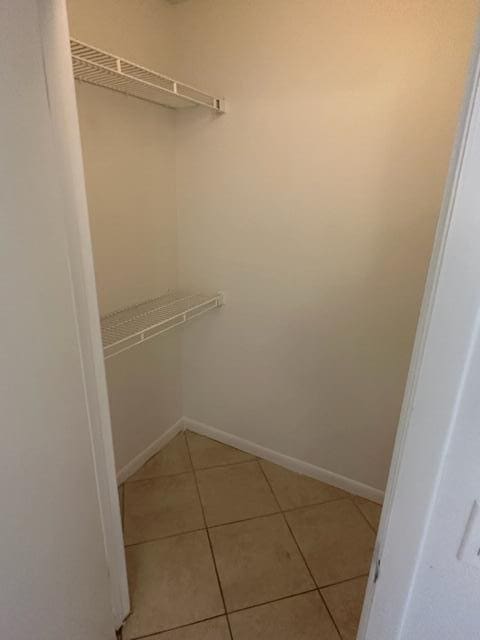 spacious closet with light tile patterned floors