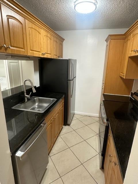 kitchen with black range oven, light tile patterned flooring, dishwasher, a textured ceiling, and sink