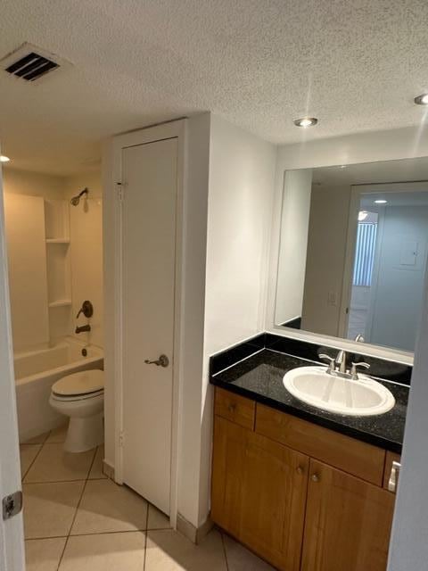 full bathroom featuring vanity, a textured ceiling, washtub / shower combination, tile patterned flooring, and toilet