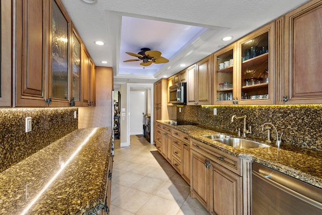 kitchen with sink, appliances with stainless steel finishes, decorative backsplash, and a raised ceiling