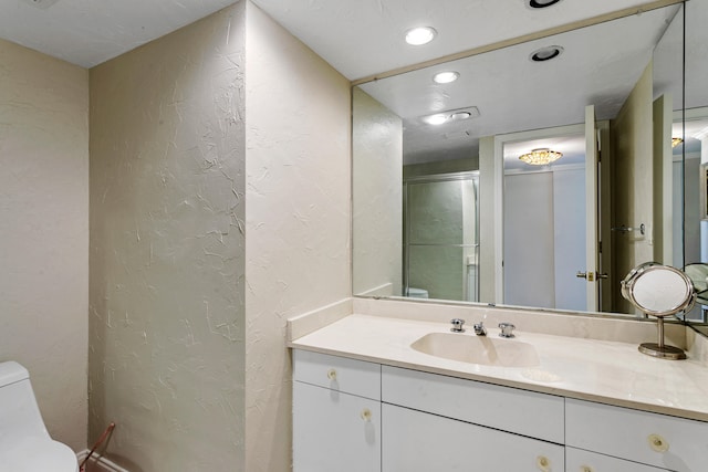 bathroom featuring vanity, toilet, and a shower with door