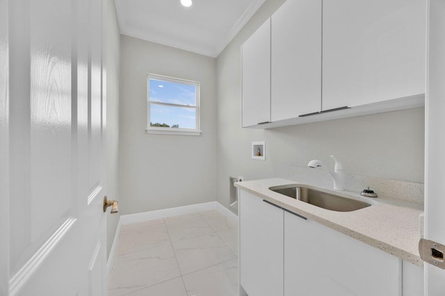 clothes washing area featuring crown molding, sink, washer hookup, and cabinets