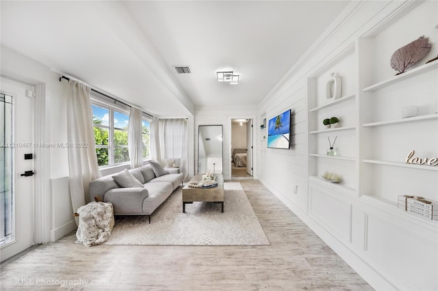 living room with light hardwood / wood-style floors and built in features