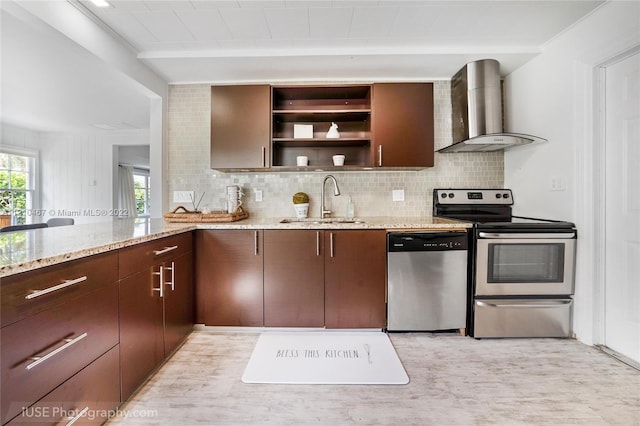 kitchen featuring decorative backsplash, wall chimney exhaust hood, light stone countertops, stainless steel appliances, and sink