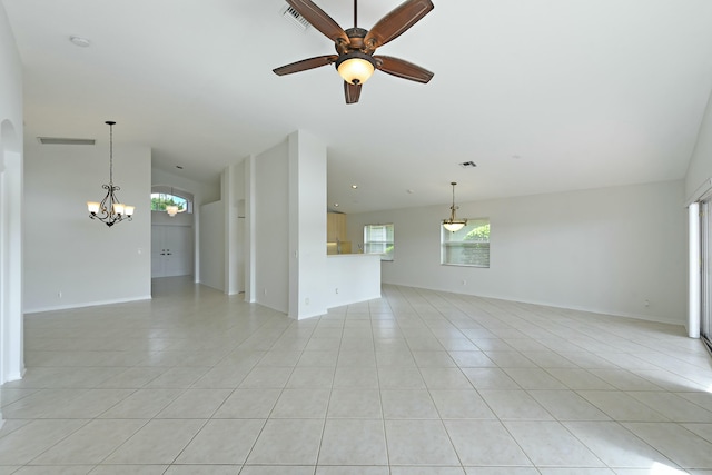 tiled empty room with ceiling fan with notable chandelier