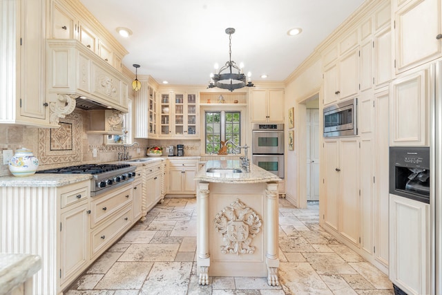 kitchen with sink, a center island with sink, backsplash, built in appliances, and light stone countertops