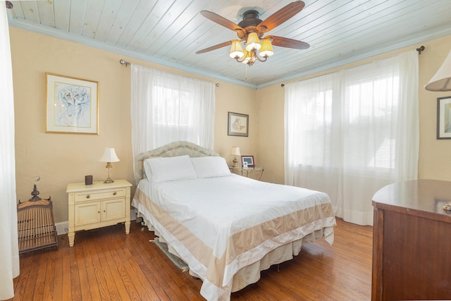 bedroom featuring wooden ceiling, multiple windows, dark hardwood / wood-style floors, and ceiling fan