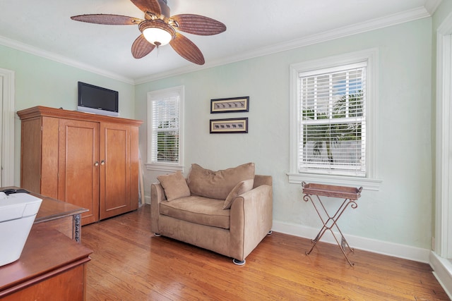 living area with light wood-type flooring, ceiling fan, and crown molding