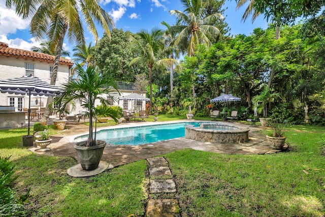 view of pool featuring a patio, a lawn, and an in ground hot tub