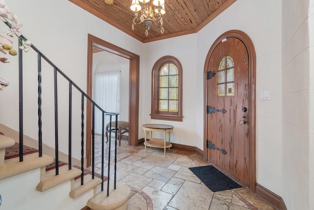 foyer entrance with wood ceiling, a notable chandelier, and ornamental molding