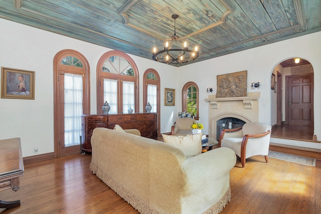 living room featuring wood-type flooring, wood ceiling, and an inviting chandelier