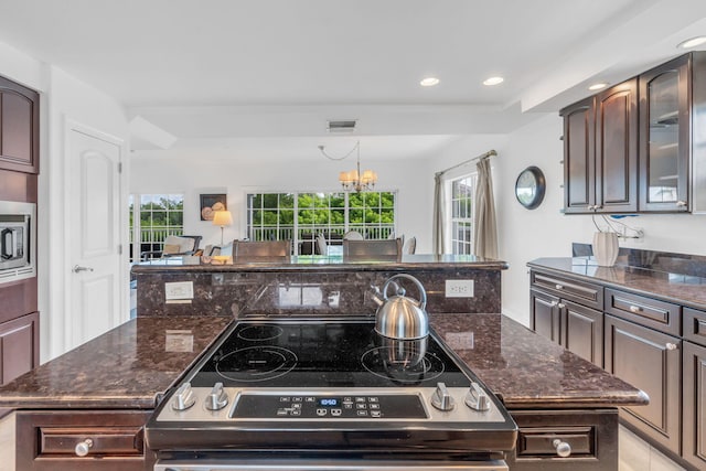 kitchen featuring a wealth of natural light, a center island, dark brown cabinetry, and range