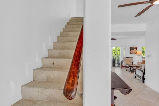 staircase featuring ceiling fan