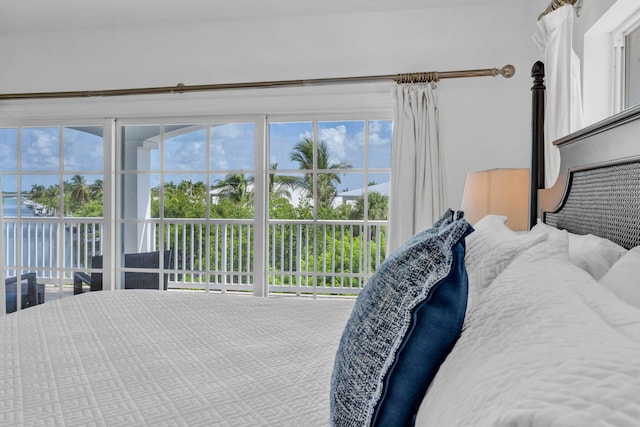 bedroom with access to exterior and a water view